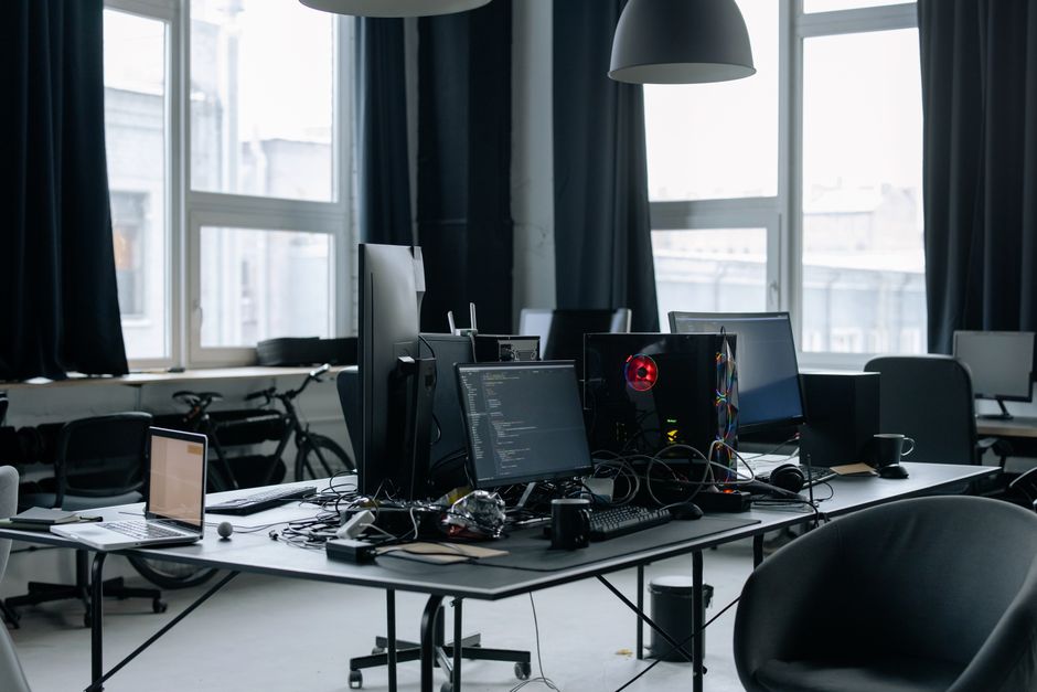 Contemporary workspace featuring computers, coding screens, and office essentials in a tech environment