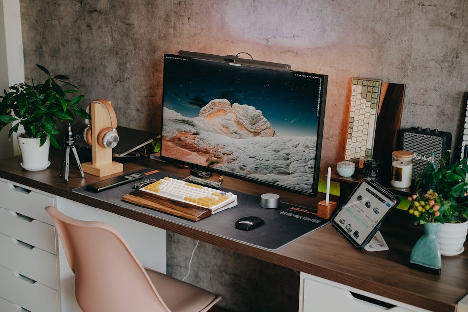 Stylish desk setup featuring a mechanical keyboard, monitor, plants, and tech gadgets.